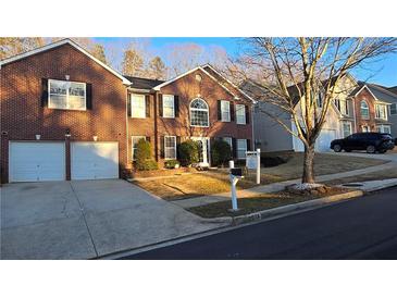 Brick house with two-car garage and well-maintained landscaping at 4038 Ash Tree St, Snellville, GA 30039