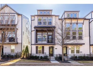 Beautiful three-story townhome featuring a balcony, fenced yard, and classic architectural design at 927 Katie Kerr Dr, Decatur, GA 30030