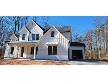 Two story home with white siding, gray roof and attached garage at 4565 Greyson Manor Dr, Cumming, GA 30041