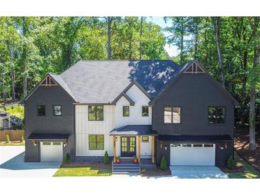 Two-story home featuring a symmetrical facade, two-car garages, and a professionally landscaped front yard at 500 Ridgewater Dr, Marietta, GA 30068
