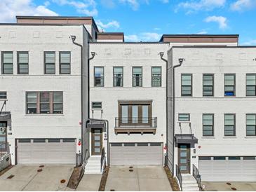 Modern townhomes featuring brick facade, private garages, and manicured landscaping at 885 Stone Crest Rd, Atlanta, GA 30324