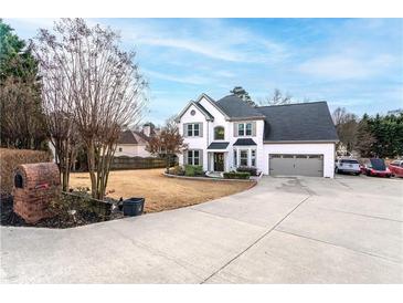 Two-story house with white brick and gray accents, two-car garage, and landscaping at 5224 Suwanee Dam Rd, Suwanee, GA 30024