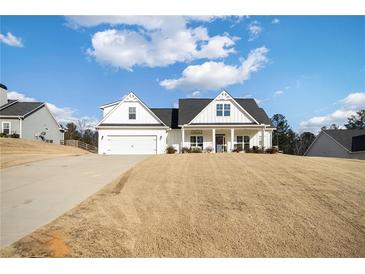 White farmhouse exterior with a large front yard and attached garage at 104 Whitley Ct, Dallas, GA 30157