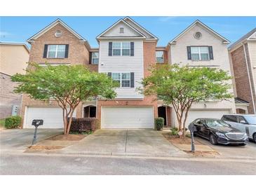 Brick front townhouse with two-car garage and landscaping at 2116 Tidal Cv, Lawrenceville, GA 30043