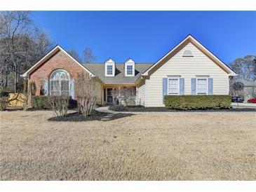 Brick and siding house with mature landscaping and a large yard at 4065 Delamar Dr, Cumming, GA 30041