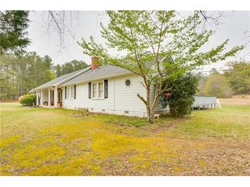Charming single-story home with a white exterior, black shutters, well-maintained lawn, and mature landscaping at 3119 E Fairview Rd, Mcdonough, GA 30252