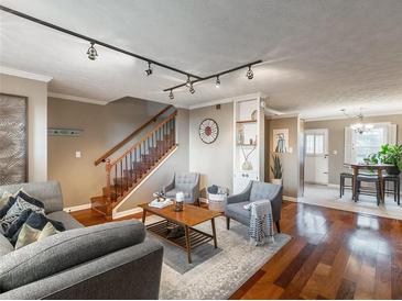 Inviting living room featuring hardwood floors, track lighting, and stairs to the second floor at 331 Lakemoore Ne Dr # C, Atlanta, GA 30342