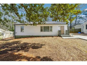 White ranch home with a metal roof, and small front yard at 1770 Lee St, Decatur, GA 30035