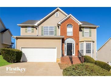 Two-story house with brick accents and a two-car garage at 415 Gresham Dr, Stockbridge, GA 30281