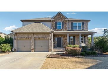 Brick two-story house with a two-car garage and landscaping at 5615 Cowles Cir, Suwanee, GA 30024