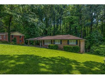 Charming brick ranch home with a sprawling lawn and mature trees, nestled in a serene, wooded setting at 6467 Joanna St, Lithia Springs, GA 30122