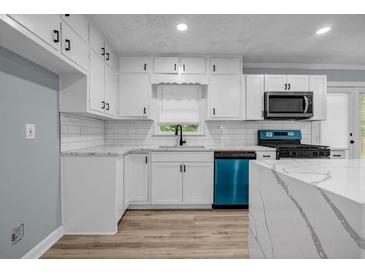 Bright kitchen features white cabinets, quartz counters, and a modern, stainless steel appliance at 6467 Joanna St, Lithia Springs, GA 30122