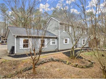 Gray house with white shutters, landscaping, and a stone retaining wall at 3570 Knoll Crest Trl, Buford, GA 30519