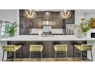 Modern kitchen with dark cabinetry, quartz countertops, and stainless steel appliances at 1107 Briar Cove Cir, Atlanta, GA 30329