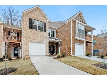 Brick front two-story townhome with attached garage and landscaping at 11118 Benton Woods Dr, Covington, GA 30014