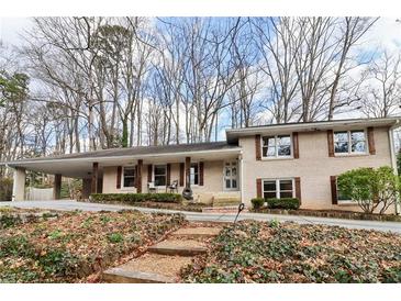 Brick ranch house with attached carport, steps leading to the front door, and landscaping at 2481 Brookdale Dr, Atlanta, GA 30345