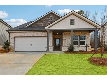 Charming single-story home with brick and stone accents, a well-manicured lawn, and attached two car garage at 3921 Brushy St, Powder Springs, GA 30127