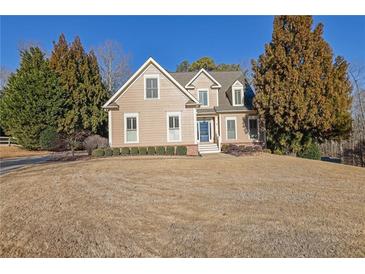 Two-story house with beige siding, landscaping, and a large yard at 4760 Green Summers Dr, Cumming, GA 30028