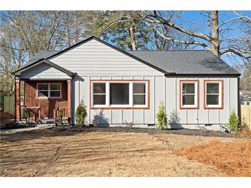 Charming bungalow with gray siding, black roof, and well-manicured front yard ready for a new homeowner at 1956 Gober Se Ave, Smyrna, GA 30080
