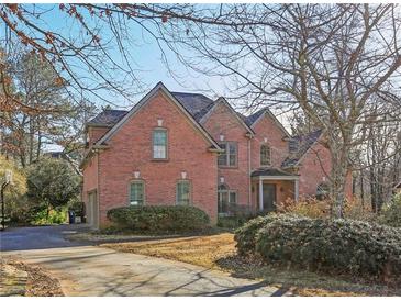 Brick two-story house with a large driveway and mature trees at 5534 Asheforde Way, Marietta, GA 30068