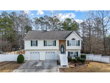 Two-story house with two-car garage, stone accents and a landscaped yard at 1620 Cedar Hl, Douglasville, GA 30134