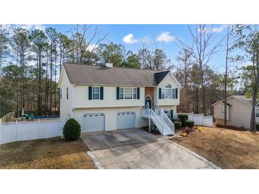 Charming home featuring a two-car garage, front staircase, and well-maintained landscaping at 1620 Cedar Hl, Douglasville, GA 30134