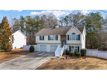 Charming two-story home with a two-car garage and a welcoming entrance with white stairs and a landscaped yard at 1620 Cedar Hl, Douglasville, GA 30134