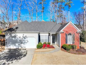 Brick and white ranch home with two-car garage and landscaping at 1843 Riverton Dr, Suwanee, GA 30024