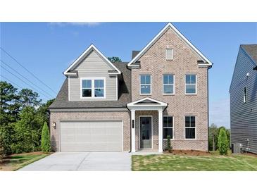 Two-story brick home with gray siding, attached garage, and landscaped lawn at 412 Newland Way, Acworth, GA 30102