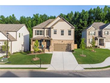 Two-story house with a light brown exterior, a two-car garage and landscaping at 4568 Mantova Dr, Buford, GA 30519