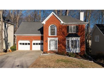 Brick house with two-car garage and landscaped lawn at 1495 Gabriel Dr, Lawrenceville, GA 30043