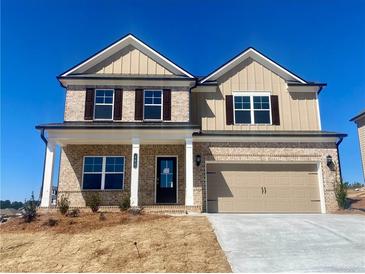Two-story home with a two-car garage and a charming brick and tan exterior at 405 Westmarch Cir, Loganville, GA 30052