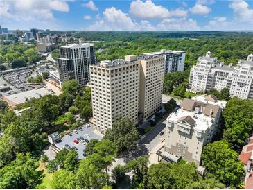 Scenic aerial view of a high rise condominium complex surrounded by lush greenery and cityscape at 2479 Peachtree Ne Rd # 407, Atlanta, GA 30305