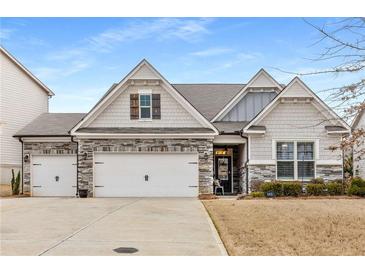 Charming home featuring a two-car garage, stone accents, and inviting curb appeal at 505 Flyingbolt Run, Canton, GA 30115