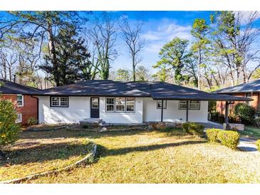 Charming ranch home with white exterior, black accents, and landscaped lawn at 2745 Fairlane Se Dr, Atlanta, GA 30354