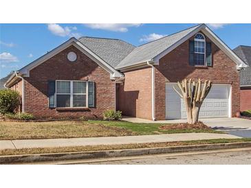 Brick ranch house with attached garage and manicured lawn at 215 Prominent Loop, Mcdonough, GA 30253