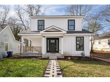 Charming two-story home with white siding, black framed windows, a front porch, and a stone walkway at 1449 Athens Sw Ave, Atlanta, GA 30310