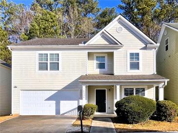Two-story house with light beige siding, a double garage, and manicured landscaping at 4534 Parkway Cir, Atlanta, GA 30349