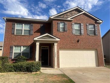 Two-story brick home featuring a two-car garage, stone accents and a well-kept front yard at 11547 Hathaway Dr, Hampton, GA 30228