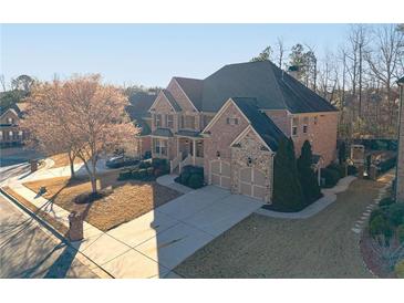 Brick home with three car garage, stone accents, and landscaping at 1828 Austins Pointe Dr, Lawrenceville, GA 30043