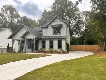 Two-story farmhouse exterior boasts a charming front porch and landscaped lawn at 1679 Eastside Parc St, Atlanta, GA 30316