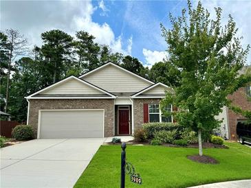 Brick home with 2-car garage, landscaping, and a welcoming front yard at 3909 Makeover Ct, Atlanta, GA 30349