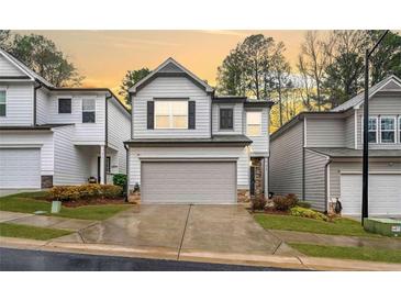 Charming two-story home featuring a well-maintained lawn and a convenient two-car garage at 319 Pinewood Dr, Woodstock, GA 30189