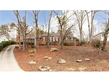 Brick house with mature trees and a long driveway at 790 Oakhaven Dr, Roswell, GA 30075