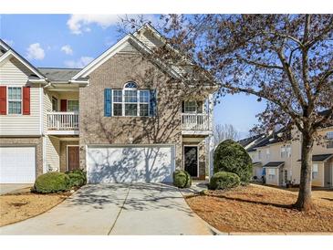 Brick front townhouse with two-story elevation, attached garage, and manicured landscaping at 4658 Grand Central Pkwy, Decatur, GA 30035