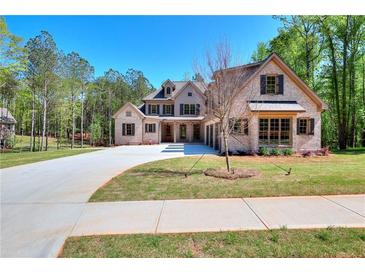 Beautiful brick home with a well-manicured lawn and long driveway leading to a three car garage at 43 Iroquois Ct, Covington, GA 30014