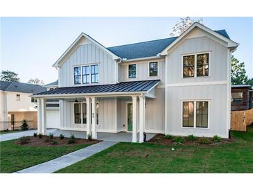 Stunning two-story farmhouse with a metal roof and charming front porch at 89 1St Ne Ave, Atlanta, GA 30317