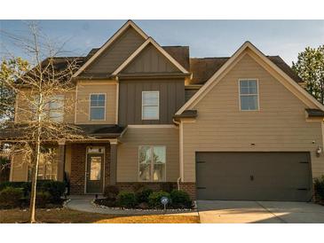 Two-story house with brick and beige siding, attached garage, and landscaping at 2496 Osceola Rd, Lithonia, GA 30058