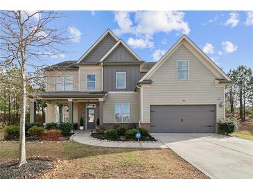 Charming two-story home features a landscaped yard, inviting front porch, and attached two-car garage at 2496 Osceola Rd, Lithonia, GA 30058