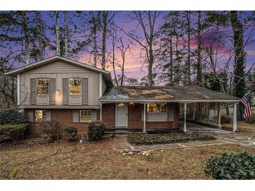 Brick ranch house with carport and mature trees in the front yard at 3310 Chisholm Sw Trl, Marietta, GA 30060